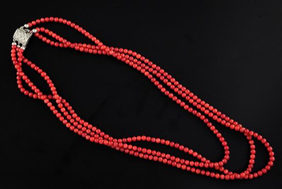 A triple strand coral bead necklace with marcasite set silver clasp, 22in.